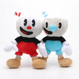 Cuphead and Mugman plush pair with striped straws, white gloves, red and blue shorts, and tan shoes