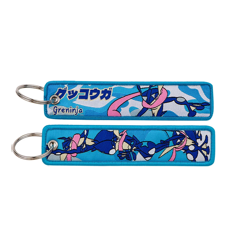 Front and back of the Greninja double-sided embroidered keychain with metal split ring