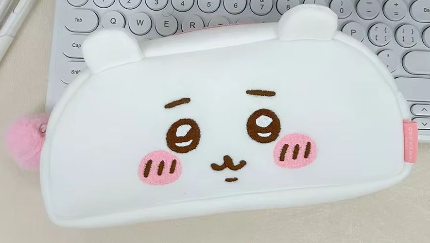 White Chiikawa plush zip pouch with pink cheeks, rounded ears and a pink zipper pull