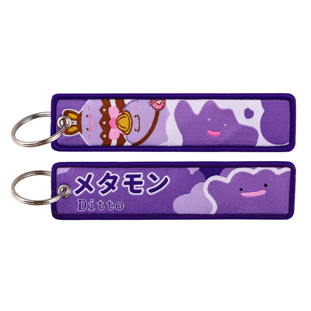 Front and back views of a purple Ditto-themed embroidered Pokémon keychain