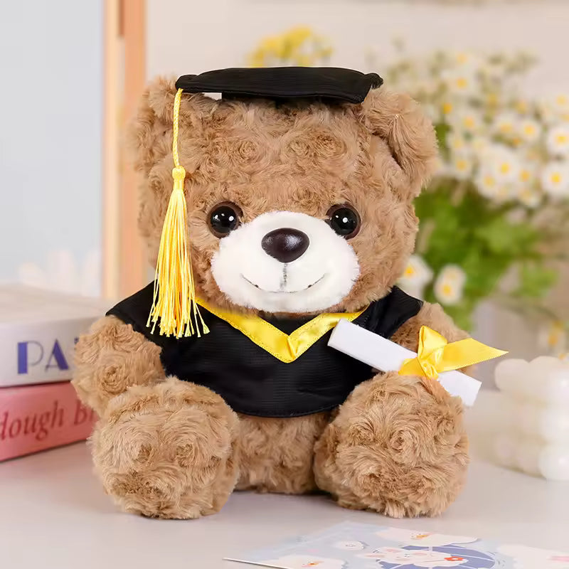 Brown graduation teddy bear with black cap and gown, yellow trim, and diploma