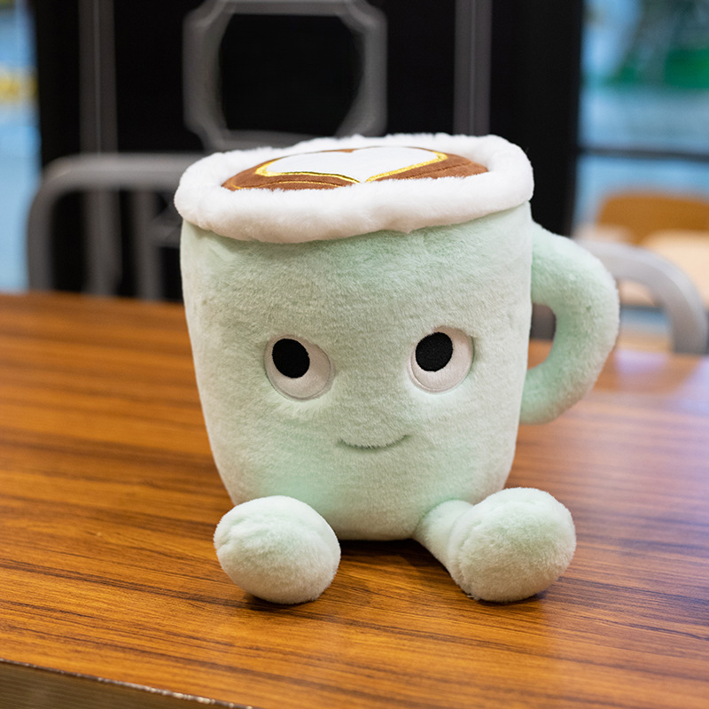 Green matcha mug plush with a handle, smiling face, latte-art top and two feet