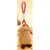 Brown peanut plush bag charm with an embroidered frowning face, pink strap and red clasp