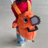 Orange Pochita plush backpack worn with two shoulder straps, a gray chainsaw detail and a zippered opening