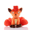 Orange Vulpix Pokémon plush with curled head fur, cream chest, brown paws, and curled tails