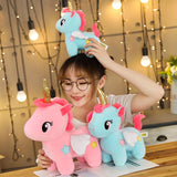 Pink and blue unicorn plush toys shown together for scale
