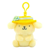Pompompurin plush keychain in a yellow hat with a pale green band, flower detail, and yellow clip