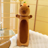 Long brown capybara plush body pillow with an orange on its head, standing against a woven screen