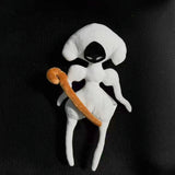 White and black Lace plush with a curved gold-colored weapon detail on a dark woven background