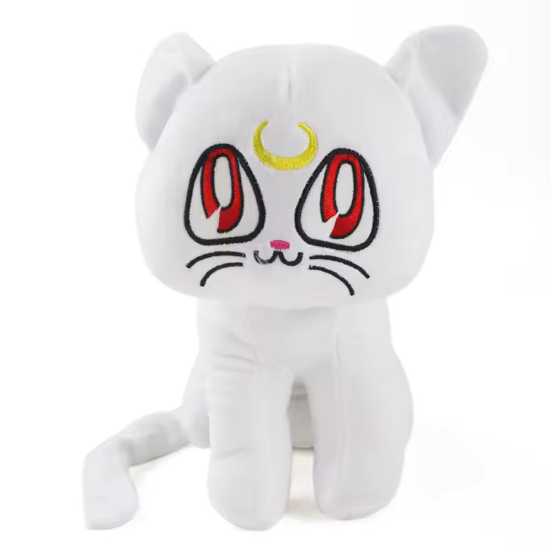 Artemis white cat plush with red embroidered eyes, yellow crescent moon, and curled tail
