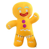 Yellow gingerbread man plush with a smiling face, purple buttons, and white icing-style trim