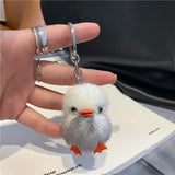 Gray-and-white fuzzy duck keychain with an orange beak and feet, a metal chain and keyring