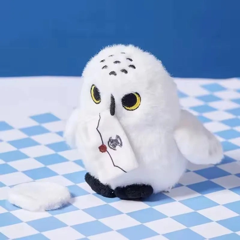 White Hedwig owl plush with yellow-ringed eyes, black beak and feet, and an envelope detail