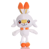 White Scorbunny plush with orange ear tips and feet, yellow face detail, and embroidered eyes