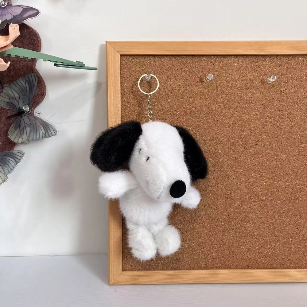 White Snoopy plush keychain with black floppy ears, an embroidered face and a metal key ring