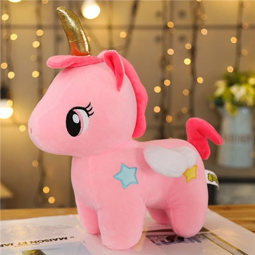 Pink unicorn plush with a golden horn, white wings, pink mane, and blue and yellow stars