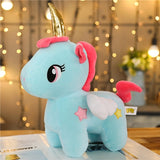 Blue unicorn plush shown with a pink unicorn in the background, with golden horns and white wings